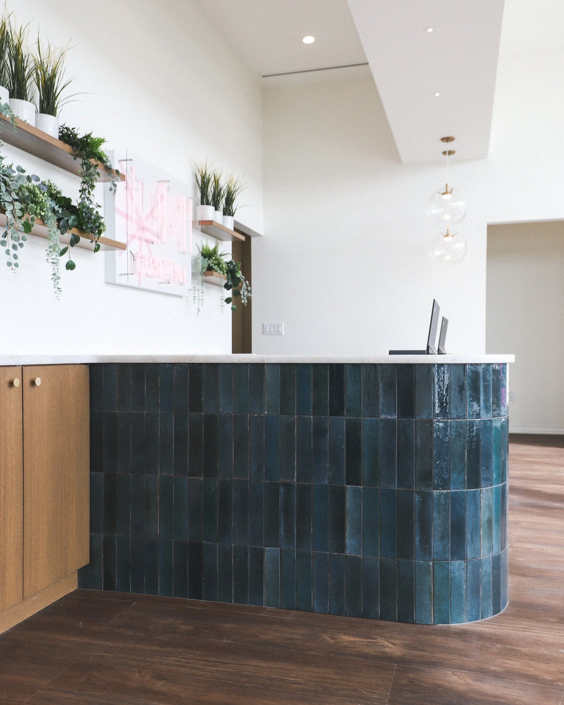 Lumi Dental reception — teal zellige tile and warm walnut floors